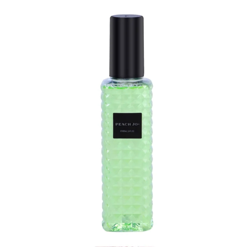 Green perfume bottle with black cap on a white background
