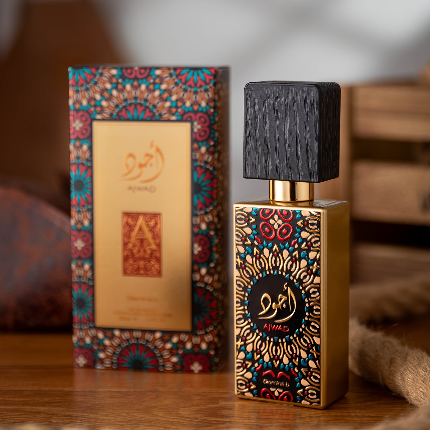 Decorative perfume bottle and box with intricate designs on a wooden surface.